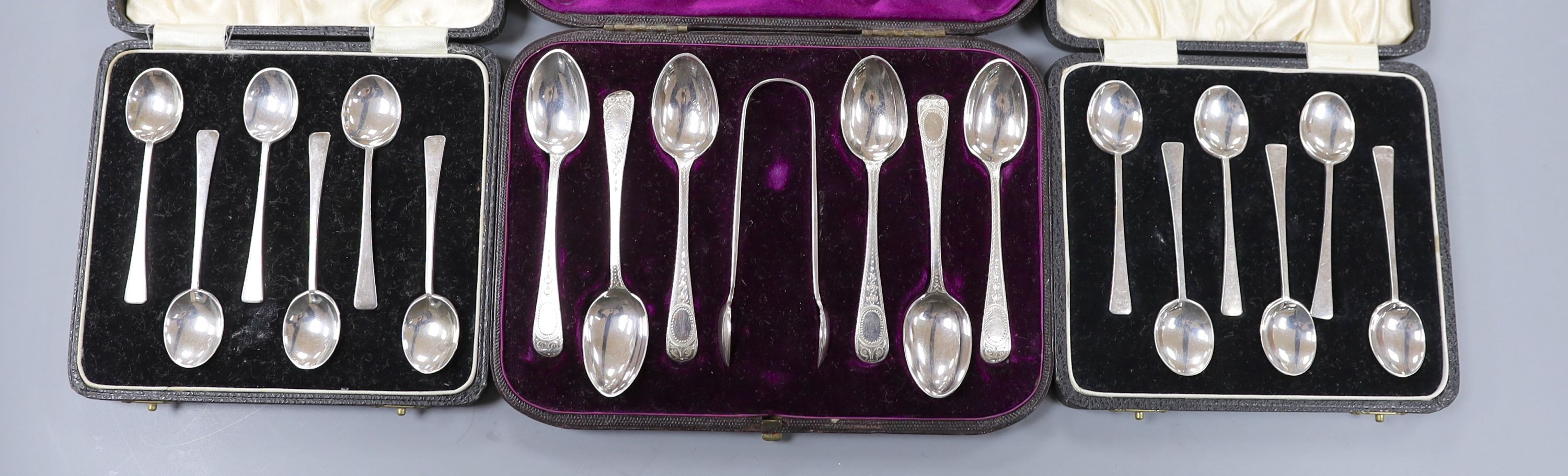 Two cased sets of six silver coffee spoons, Birmingham and a cased set of six engraved silver teaspoons with tongs, London, 1878, 5oz.